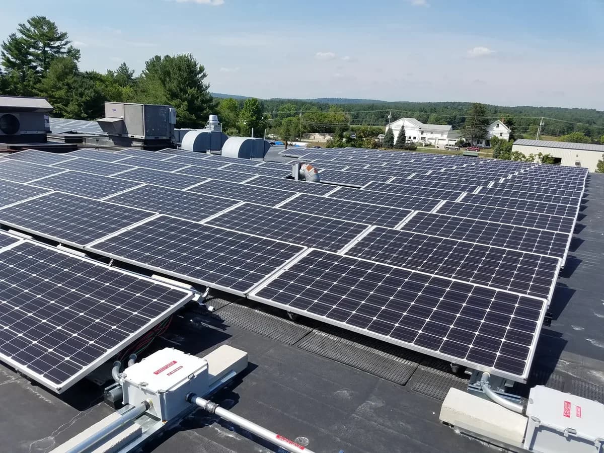 Roof-level view across the commercial solar panels at Amherst Label in Milford New Hampshire