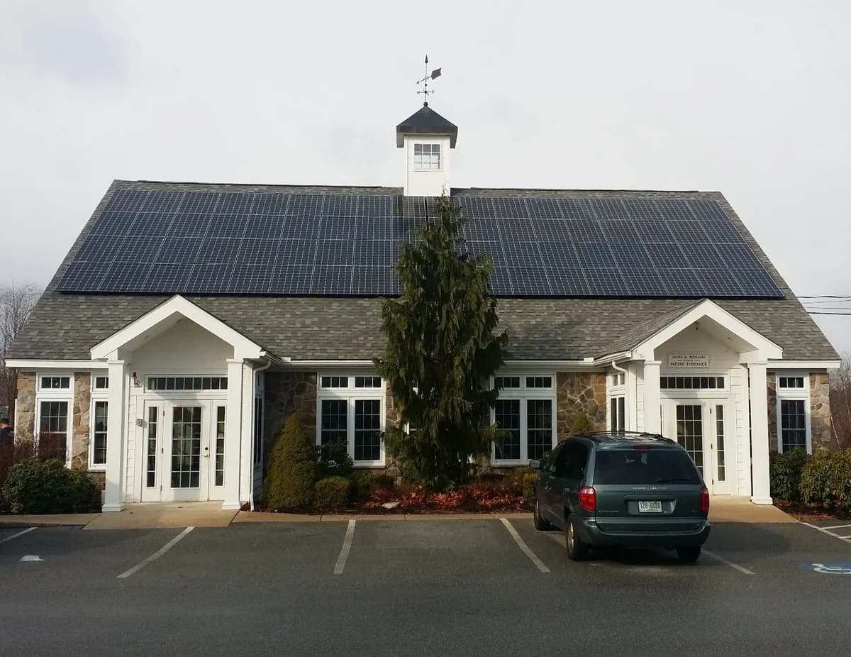 Ground-level view of the completed rooftop solar array at Holland Orthodontics in Hampstead New Hampshire