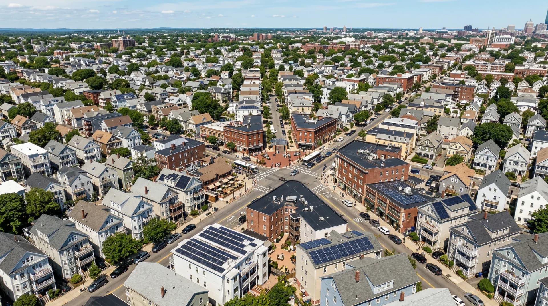 Aerial view of Somerville Massachusetts triple-deckers with solar panels on flat rooftops