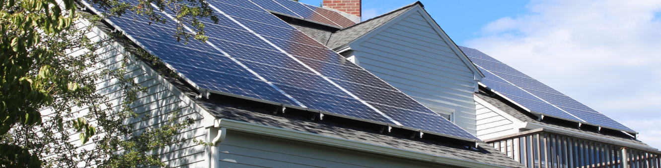 Solar panels installed by NuWatt catch the sun on a New Hampshire home.